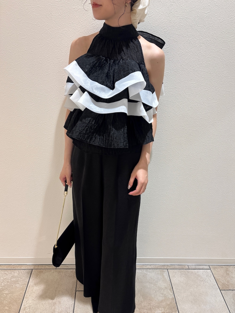 ブラック系のパンツドレス、ブラック系のハンドバッグ、ブラック系のパンプスを着用したレディースの秋コーディネートの6枚目の写真