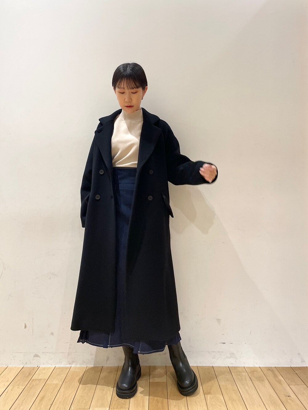 ホワイト系のニット/セーター、ブルー系のスカート、ブラック系のブーツを着用したレディースの冬コーディネートの8枚目の写真