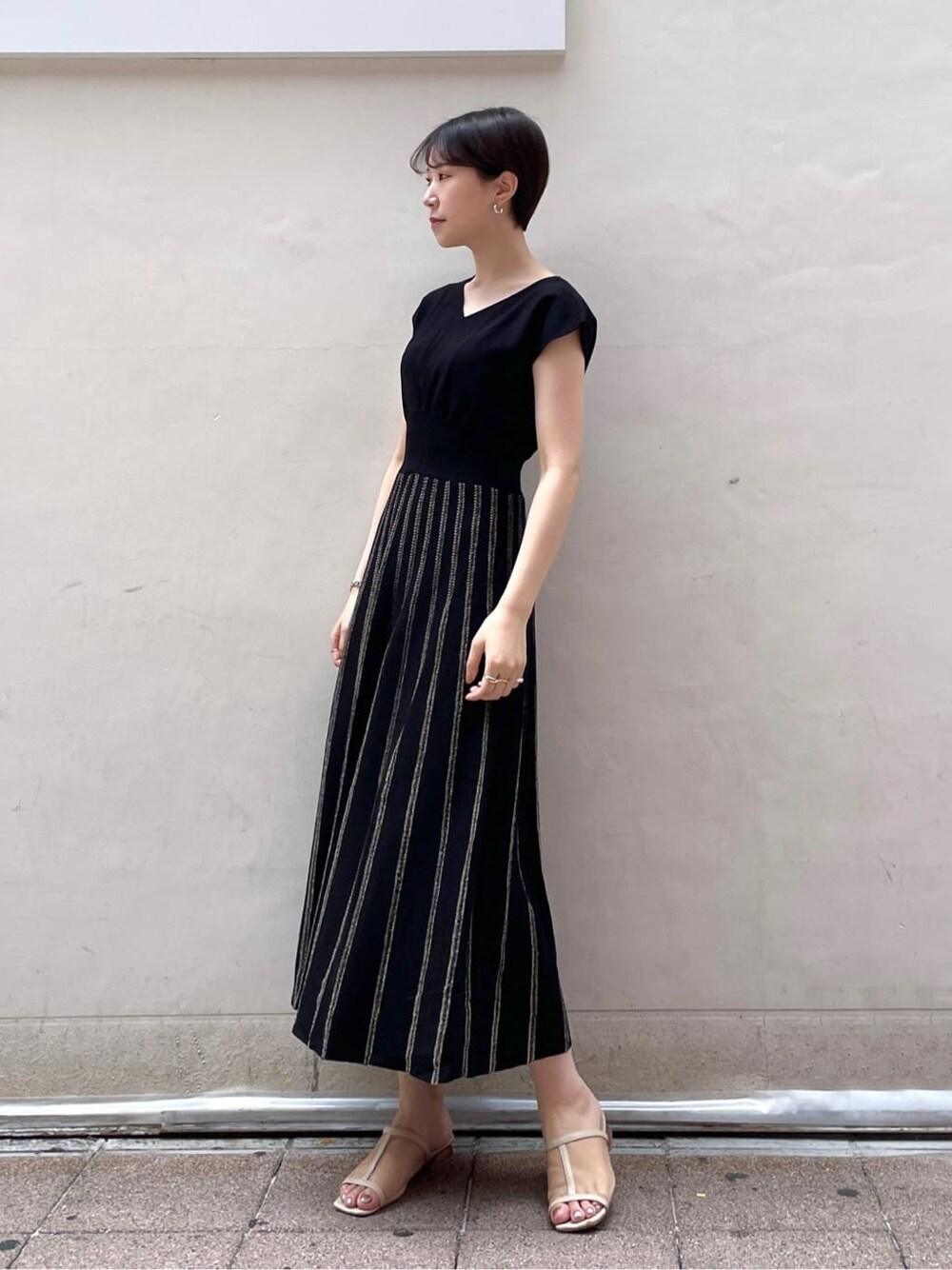 レッド系のサンダル、ブラック系のワンピースを着用したレディースの夏コーディネートの3枚目の写真