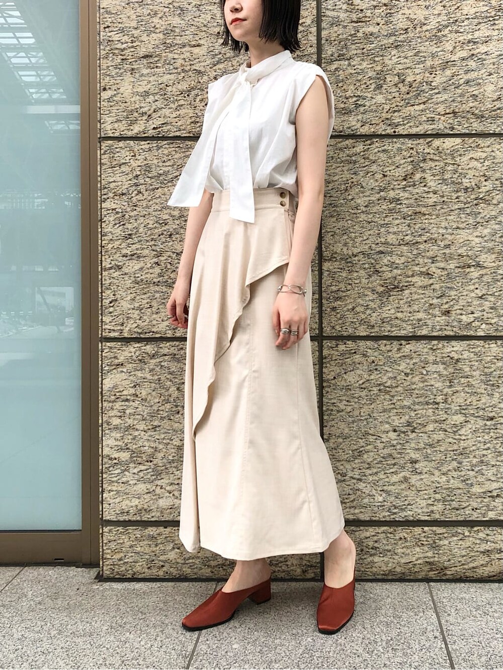 ホワイト系のシャツ/ブラウス、ホワイト系のスカート、オレンジ系のスリッポンを着用したレディースの夏コーディネートの5枚目の写真