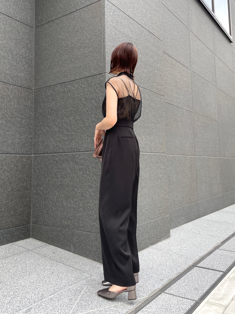 その他のパンプス、ゴールド系のクラッチバッグ、ブラック系のパンツドレスを着用したレディースの春コーディネートの3枚目の写真