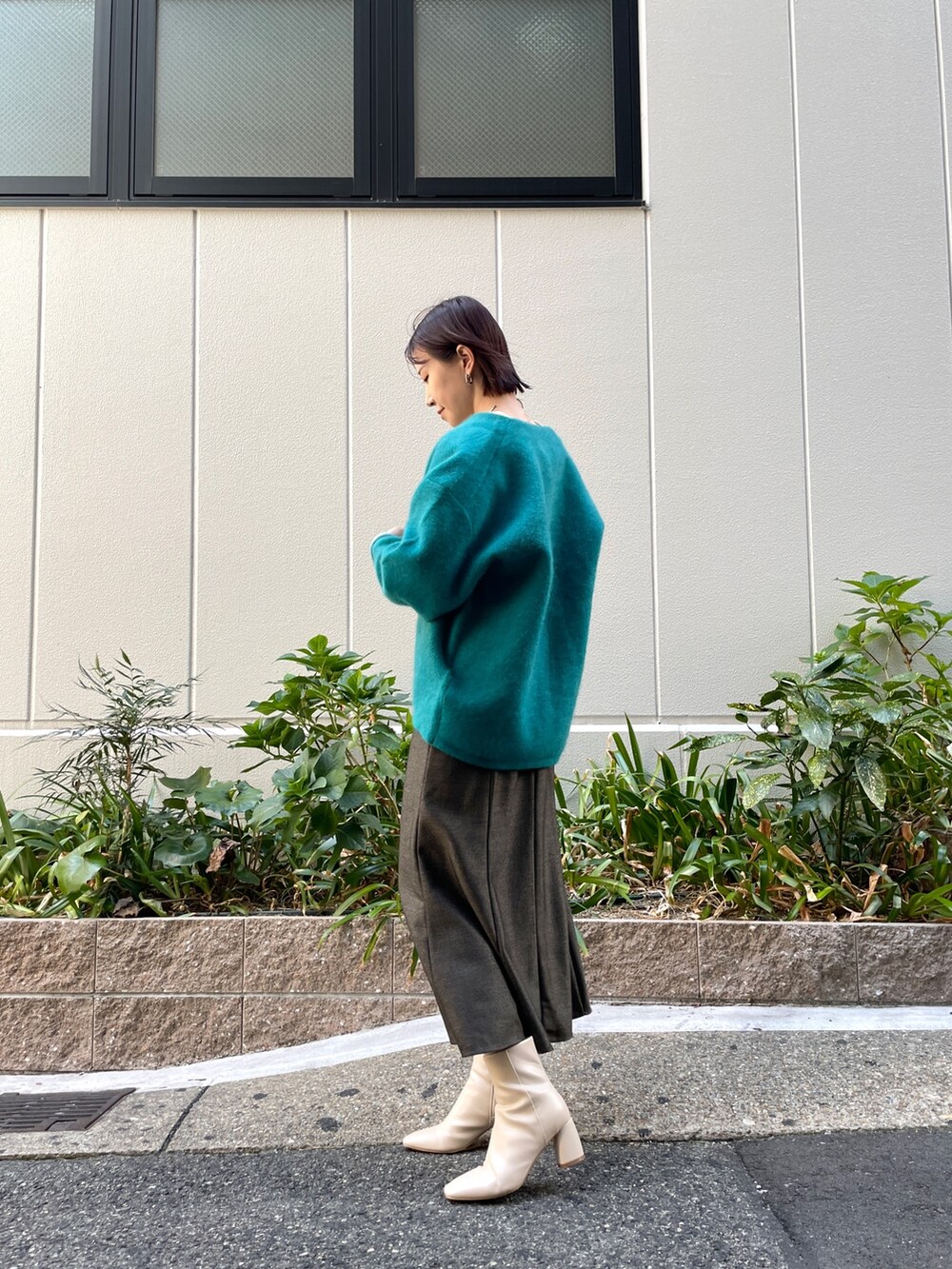 ブルー系のカーディガン/ボレロ、ブラウン系のワンピース、ホワイト系のブーツを着用したレディースの秋コーディネートの3枚目の写真