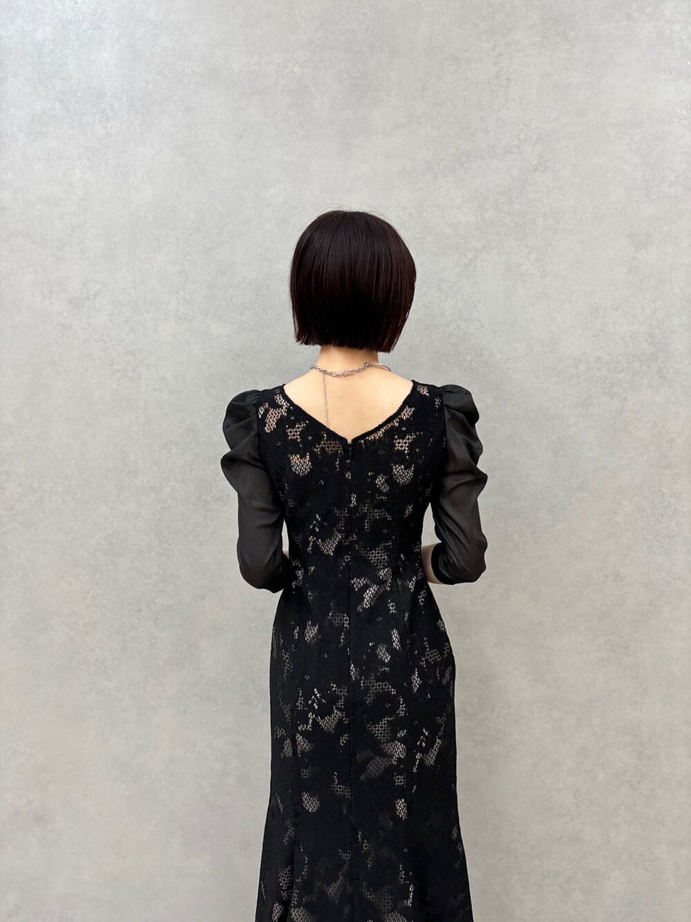 ブラック系のドレス、ブラック系のパンプスを着用したレディースの秋コーディネートの5枚目の写真