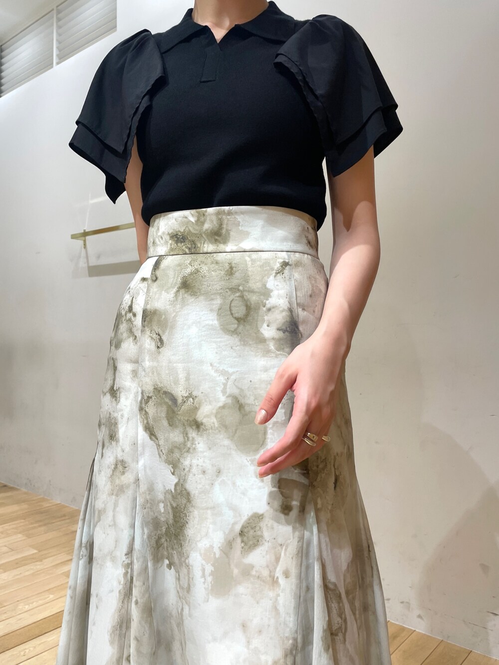 ブラック系のサンダル、グレー系のスカート、ブラック系のニット/セーターを着用したレディースの夏コーディネートの6枚目の写真