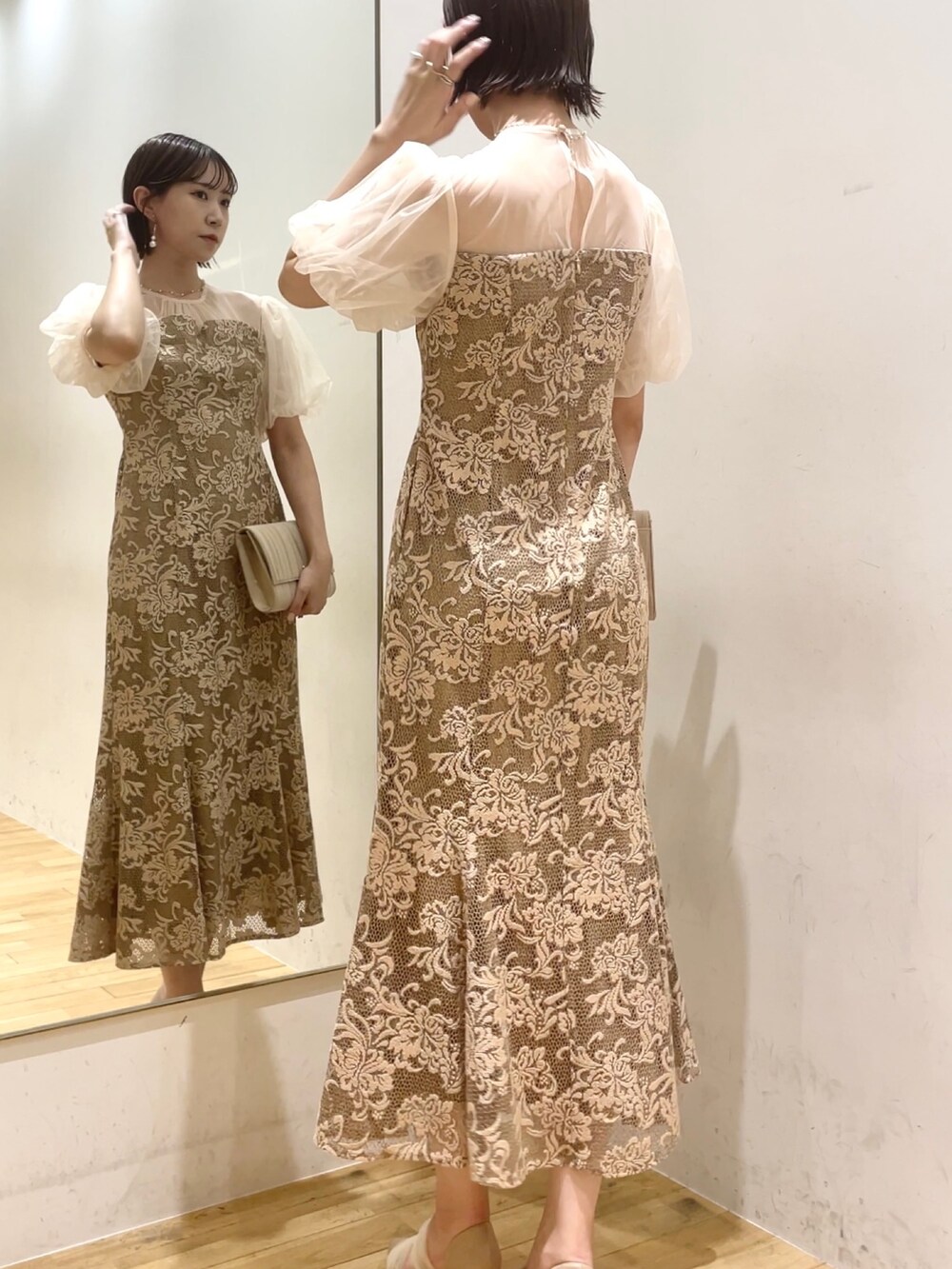 ベージュ系のハンドバッグ、ベージュ系のパンプス、ベージュ系のドレスを着用したレディースの秋コーディネートの6枚目の写真