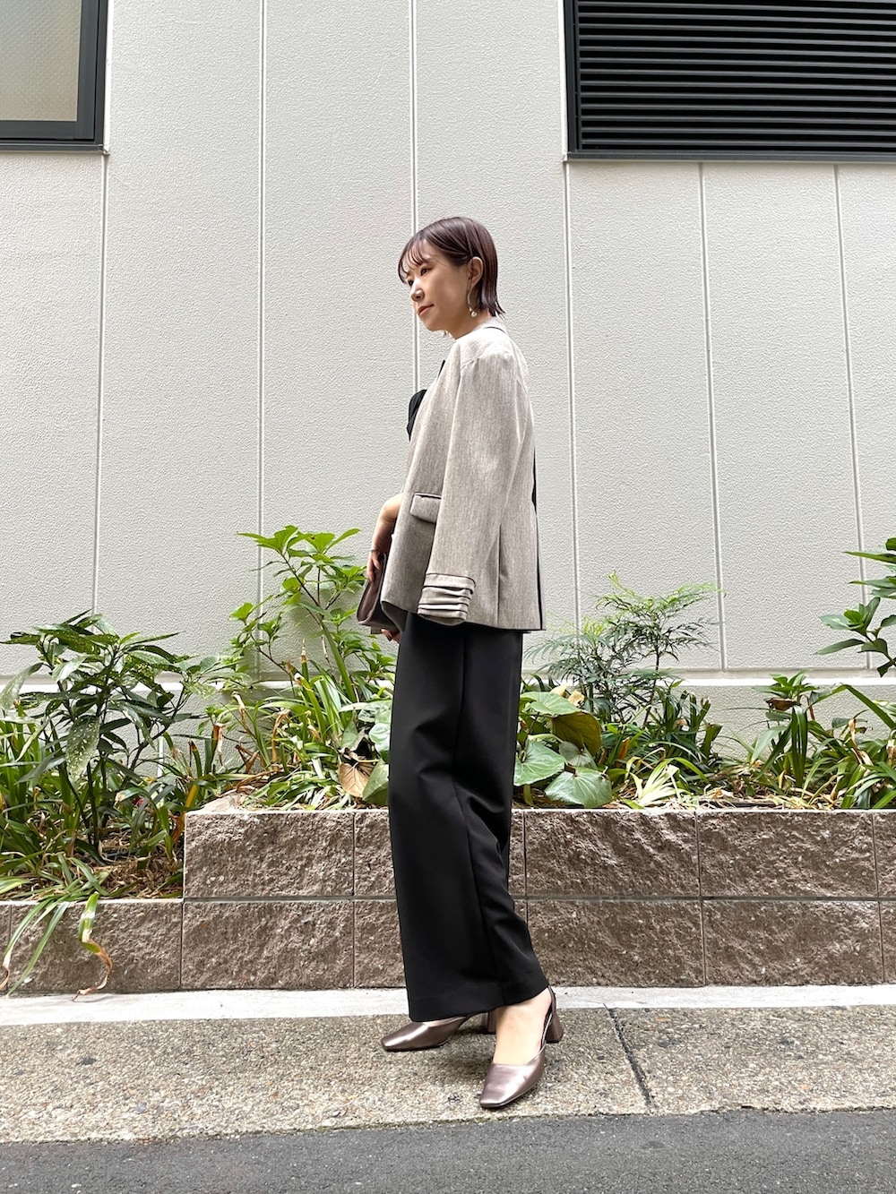 その他のパンプス、ブラック系のパンツドレス、シルバー系のハンドバッグを着用したレディースの秋コーディネートの2枚目の写真