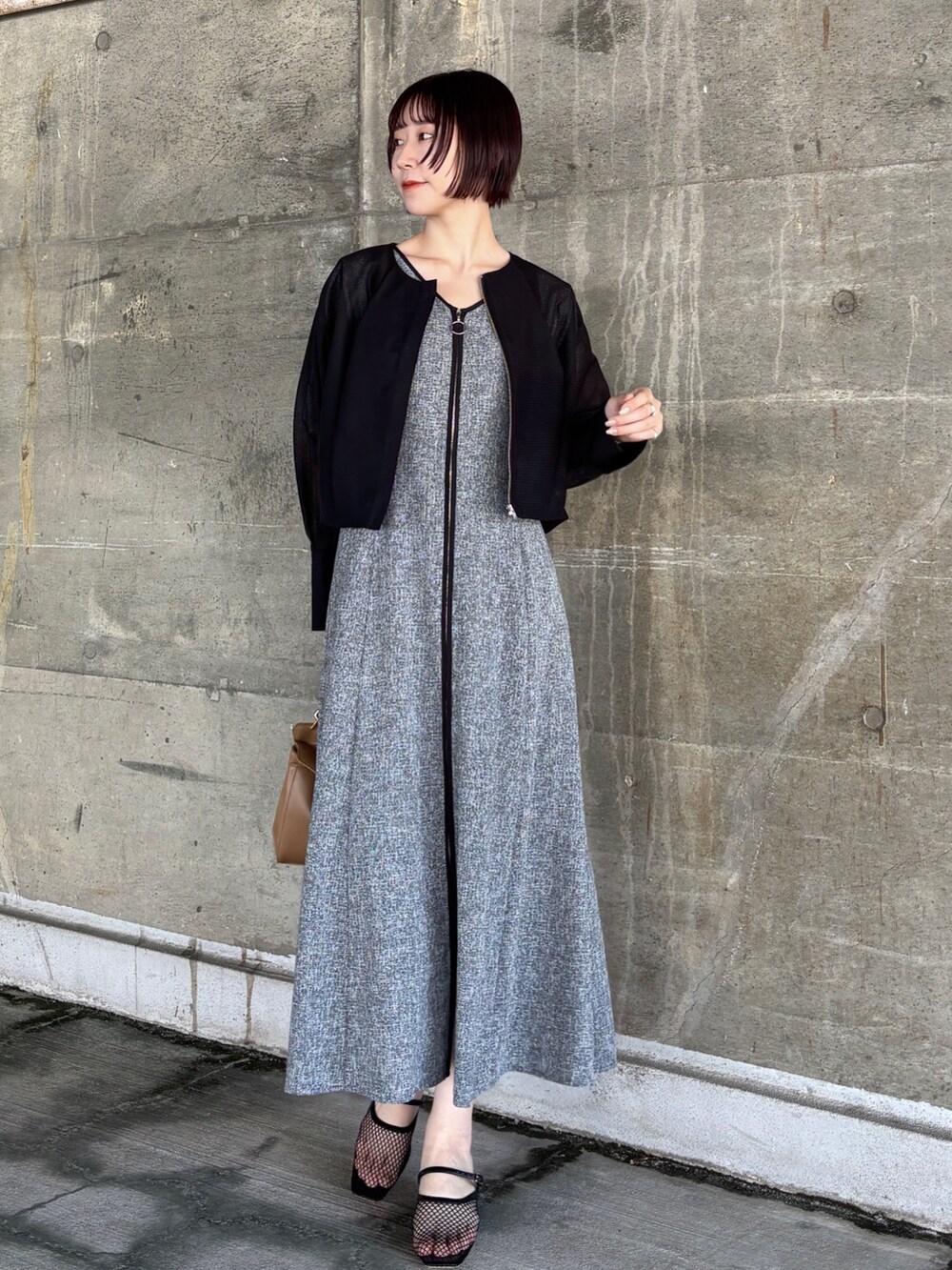 ブラック系のワンピース、イエロー系のハンドバッグ、ブラック系のサンダルを着用したレディースの夏コーディネートの8枚目の写真