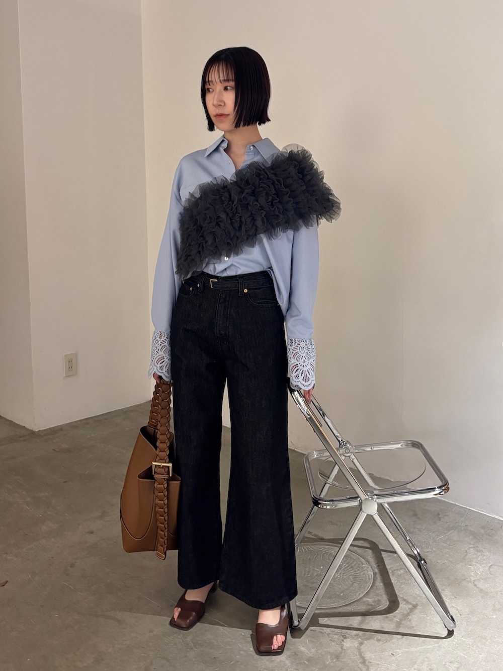 ブラック系のデニムパンツ、ブラウン系のサンダル、ブルー系のシャツ/ブラウスを着用したレディースの春コーディネートの3枚目の写真