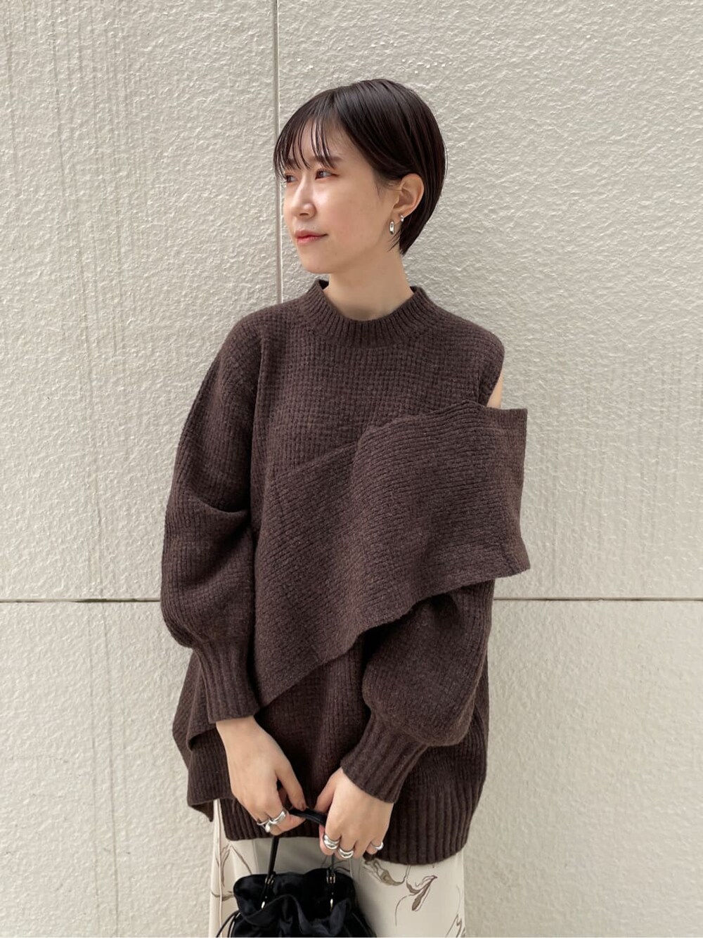 ブラック系のその他シューズ、ブラック系のハンドバッグ、ホワイト系のスカートを着用したレディースの冬コーディネートの3枚目の写真