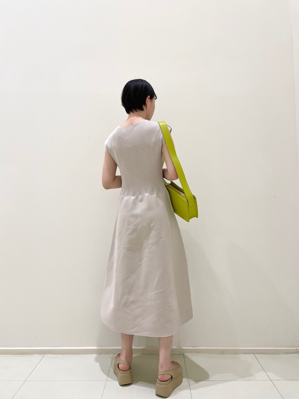 ベージュ系のサンダル、グリーン系のショルダーバッグ、グレー系のワンピースを着用したレディースの春コーディネートの4枚目の写真