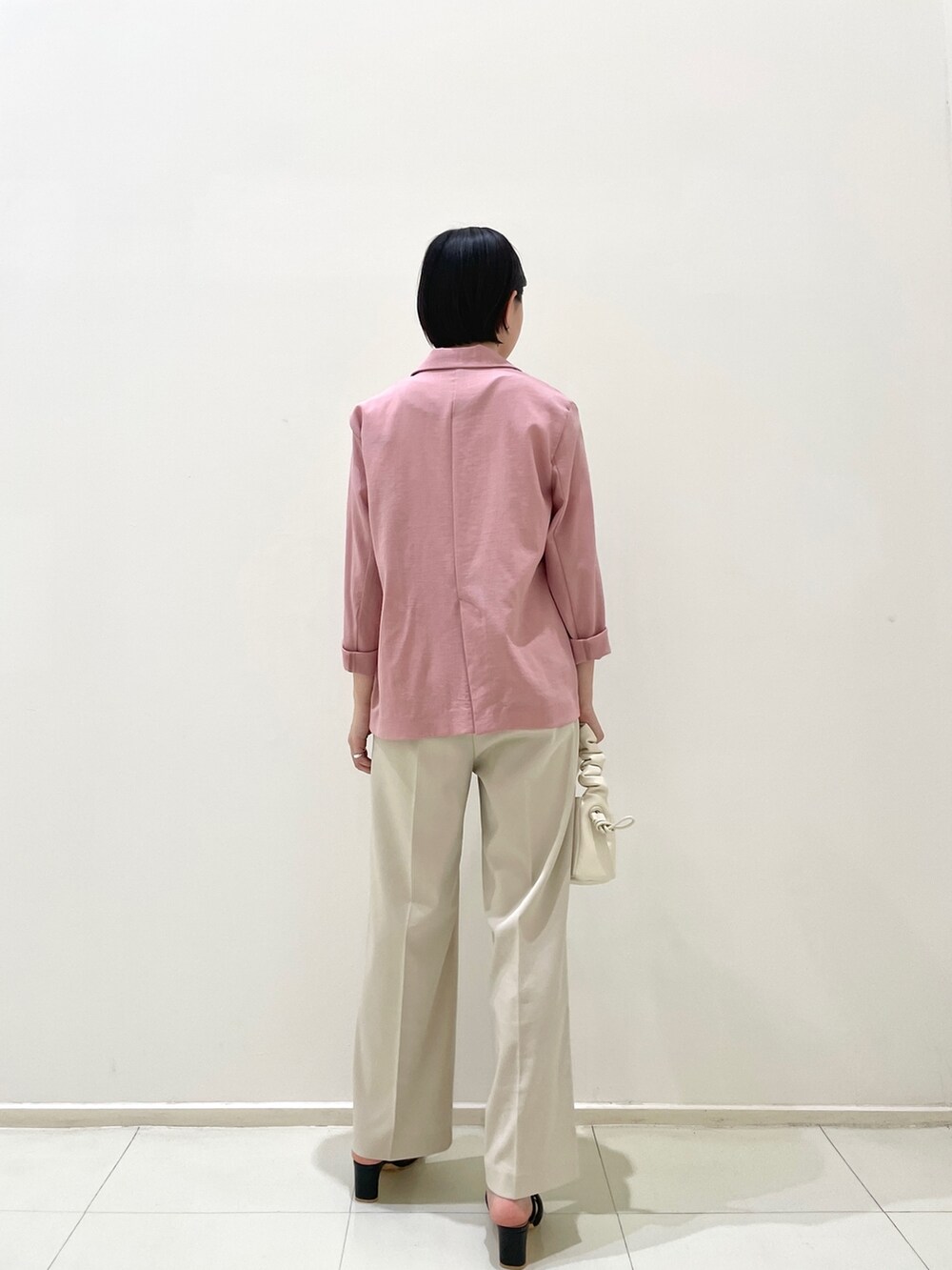 ピンク系のテーラードジャケット、ホワイト系のその他パンツ、ホワイト系のニット/セーターを着用したレディースの春コーディネートの5枚目の写真