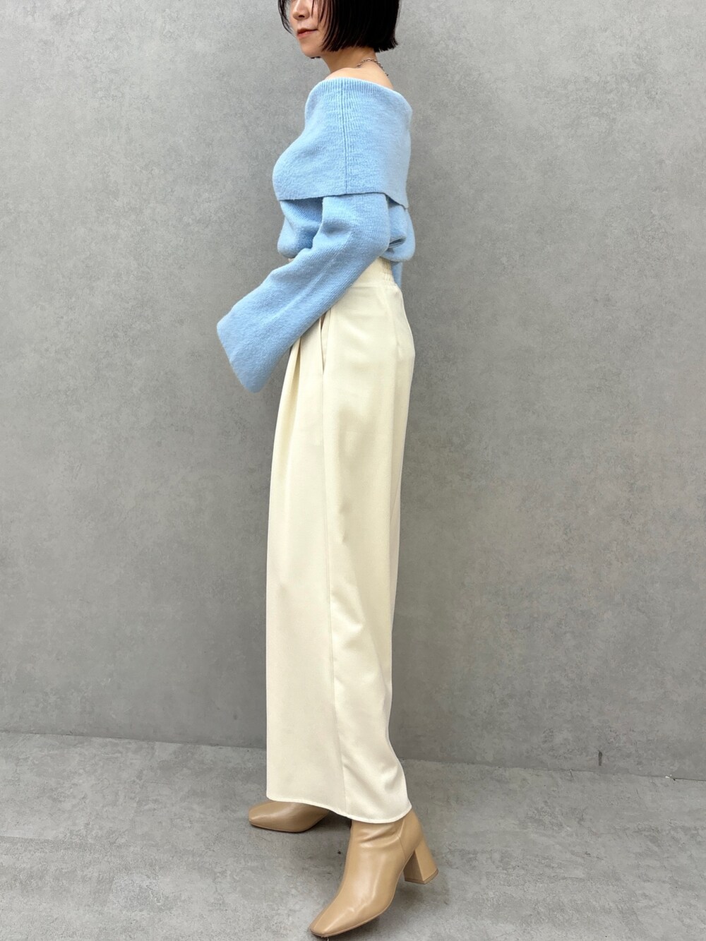 ブルー系のニット/セーター、ホワイト系のその他パンツを着用したレディースの秋コーディネートの5枚目の写真