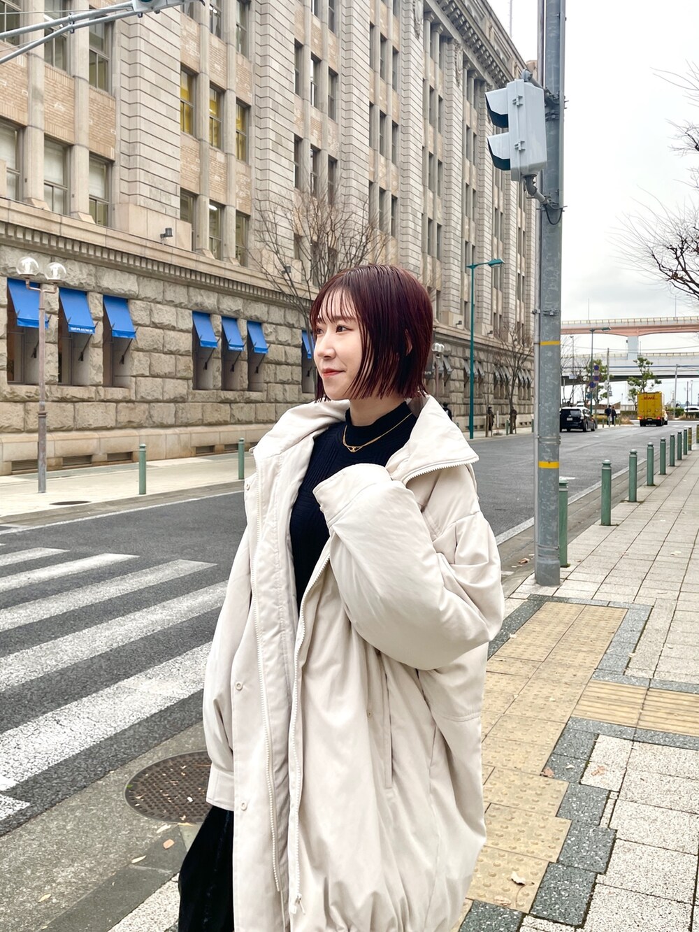 ホワイト系のダウンジャケット/コート、ブラック系のワンピースを着用したレディースの冬コーディネートの6枚目の写真