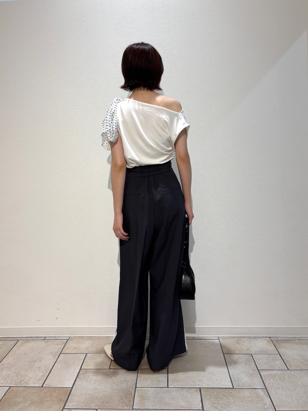 グレー系のその他パンツ、ホワイト系のサンダル、ブラック系のハンドバッグを着用したレディースの夏コーディネートの3枚目の写真