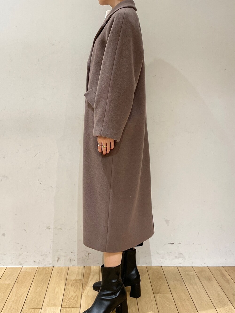 ホワイト系のニット/セーター、ブラック系のスカート、ブラック系のブーツを着用したレディースの冬コーディネートの7枚目の写真