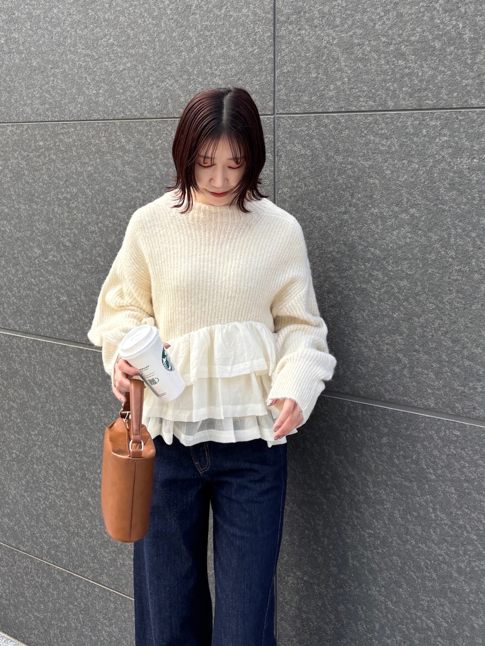 ブルー系のデニムパンツ、イエロー系のハンドバッグ、ホワイト系のニット/セーターを着用したレディースの冬コーディネートの4枚目の写真