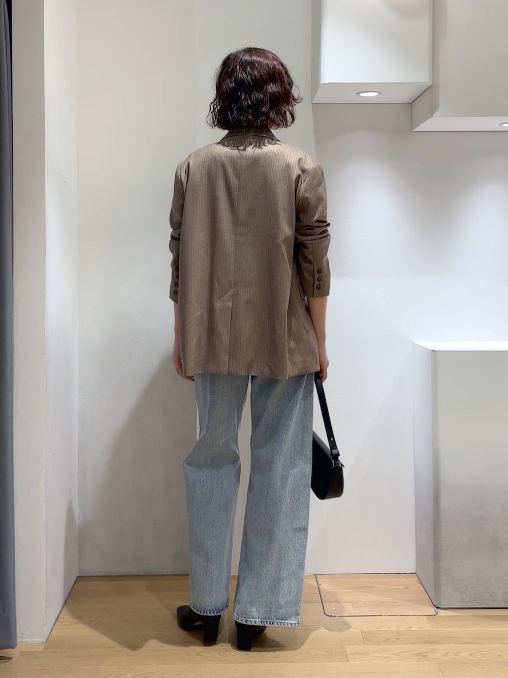 ホワイト系のニット/セーター、ブルー系のデニムパンツ、ブラック系のブーツを着用したレディースの秋コーディネートの3枚目の写真