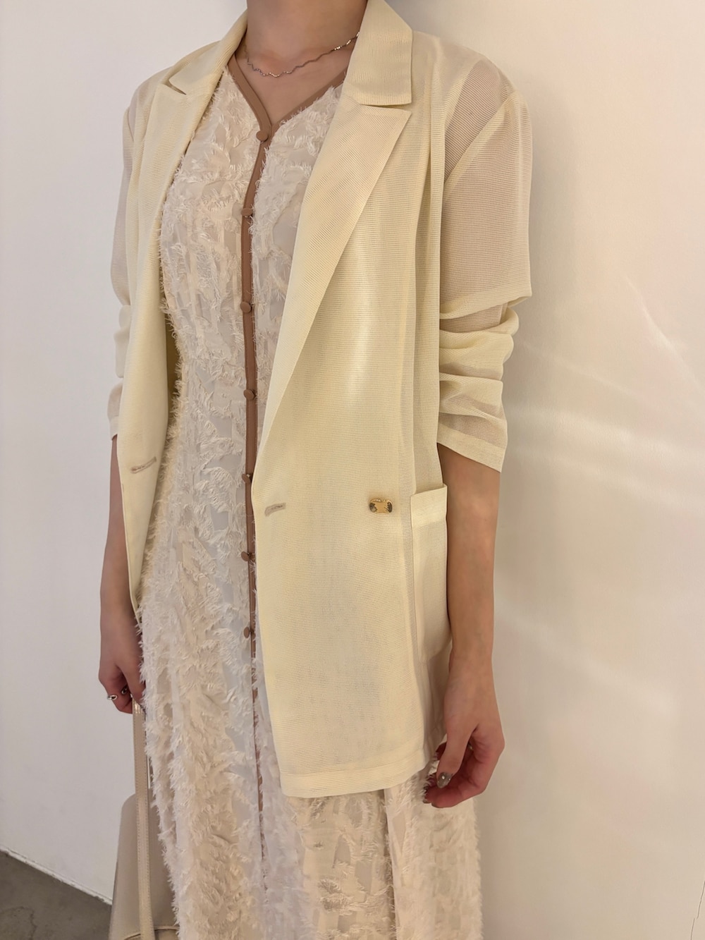 ホワイト系のワンピース、グリーン系のパンプスを着用したレディースの春コーディネートの4枚目の写真