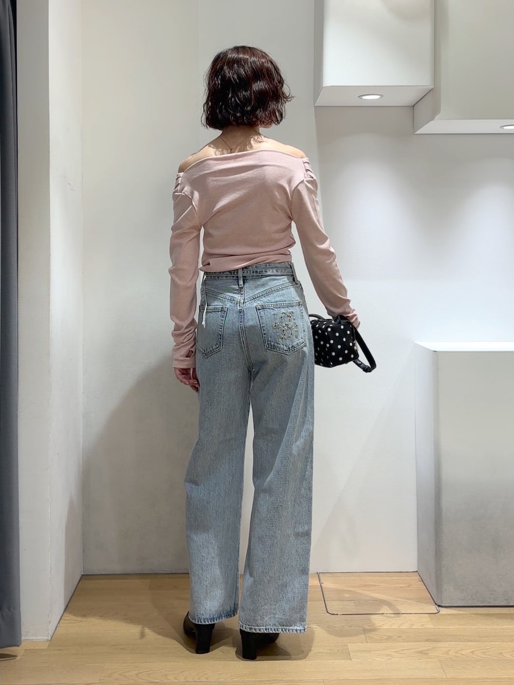 ピンク系のニット/セーター、ブルー系のデニムパンツ、ブラック系のブーツを着用したレディースの秋コーディネートの3枚目の写真