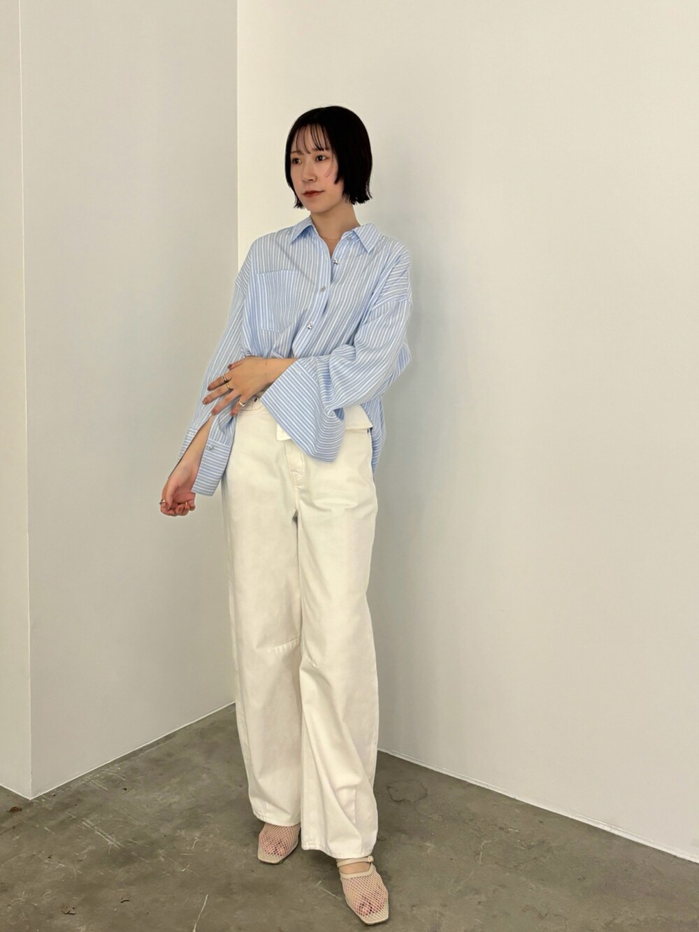 ブルー系のシャツ/ブラウス、ホワイト系のデニムパンツ、ホワイト系のサンダルを着用したレディースの冬コーディネートの4枚目の写真