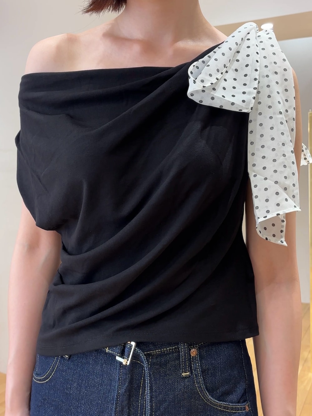 ブルー系のデニムパンツ、ブラック系のハンドバッグ、シルバー系のパンプスを着用したレディースの夏コーディネートの8枚目の写真