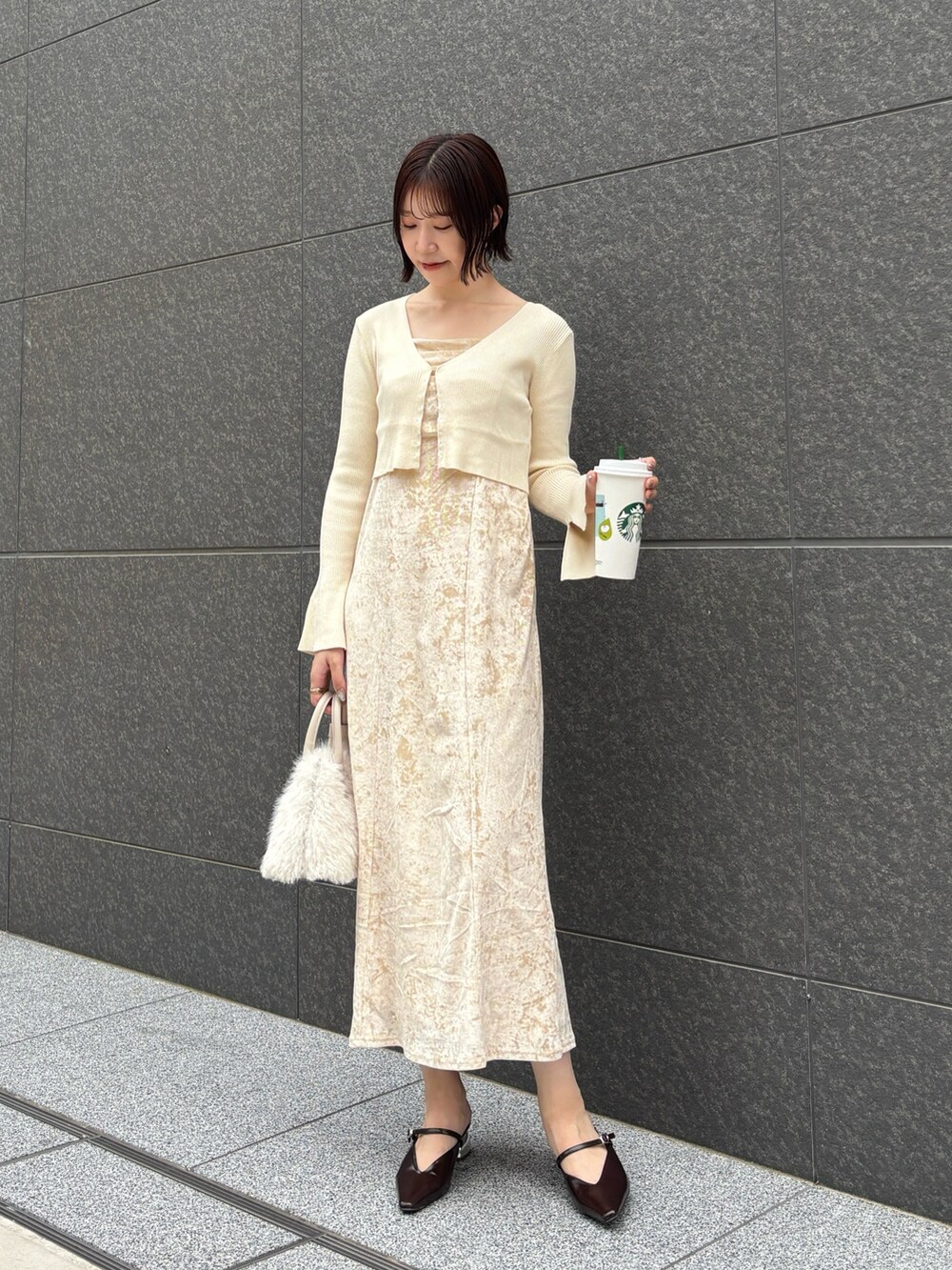 ベージュ系のワンピース、ホワイト系のボストンバッグ、ブラウン系のパンプスを着用したレディースの秋コーディネートの2枚目の写真