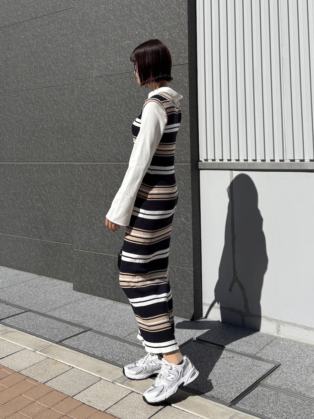 ベージュ系のワンピース、ブラック系のハンドバッグを着用したレディースの春コーディネートの2枚目の写真