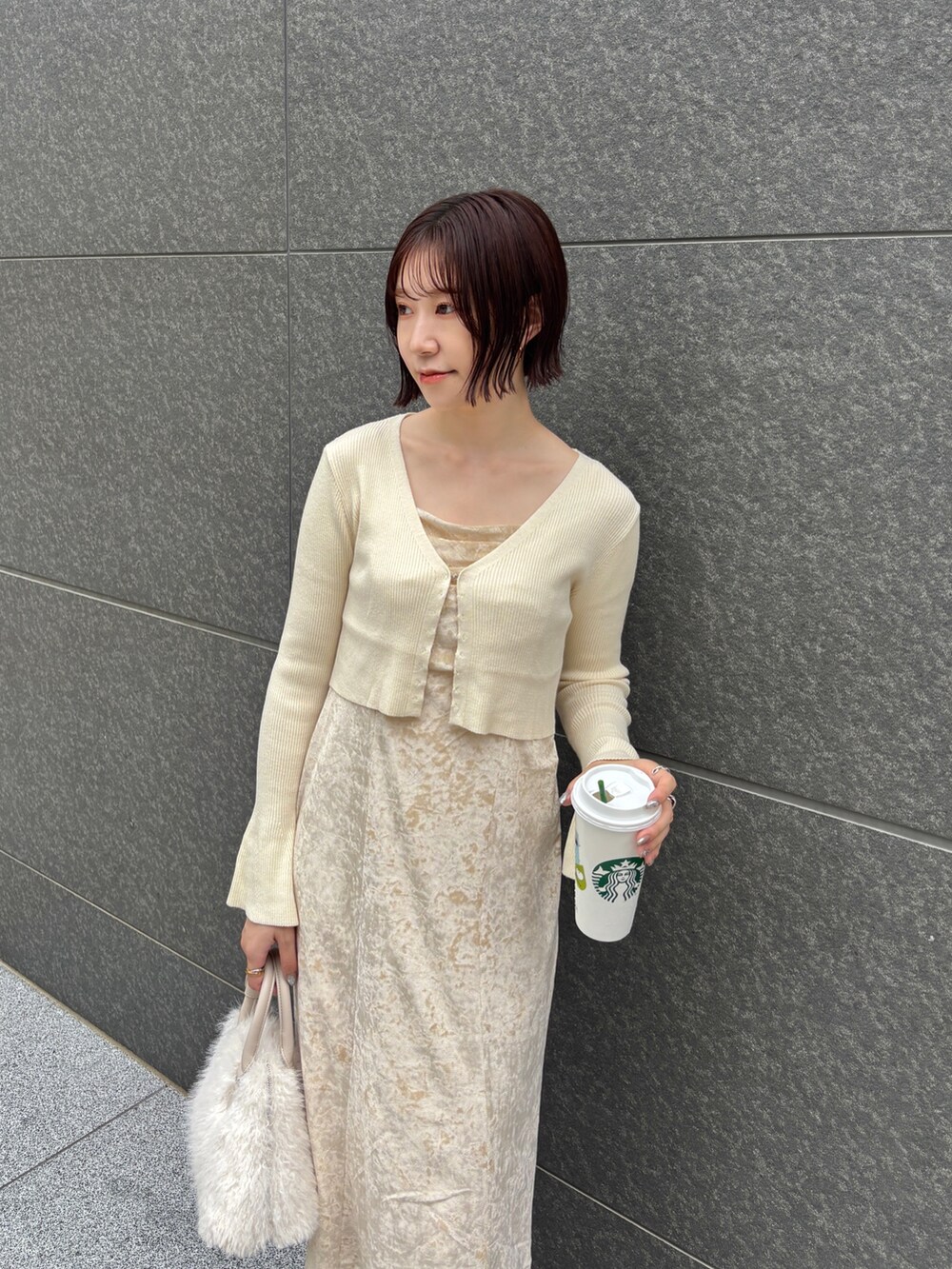 ベージュ系のワンピース、ホワイト系のボストンバッグ、ブラウン系のパンプスを着用したレディースの秋コーディネートの5枚目の写真