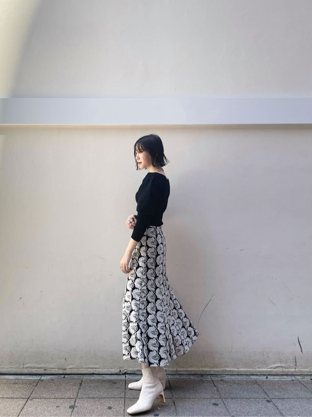 ブラック系のスカート、ブラウン系のショルダーバッグ、ホワイト系のその他シューズを着用したレディースの秋コーディネートの2枚目の写真