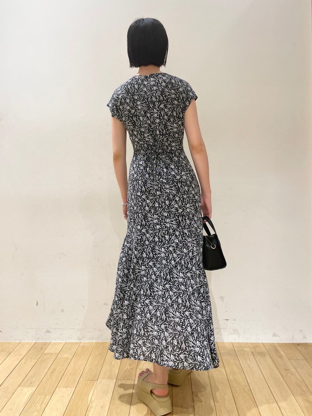 ブラック系のワンピース、ブラック系のショルダーバッグ、ベージュ系のサンダルを着用したレディースの夏コーディネートの5枚目の写真