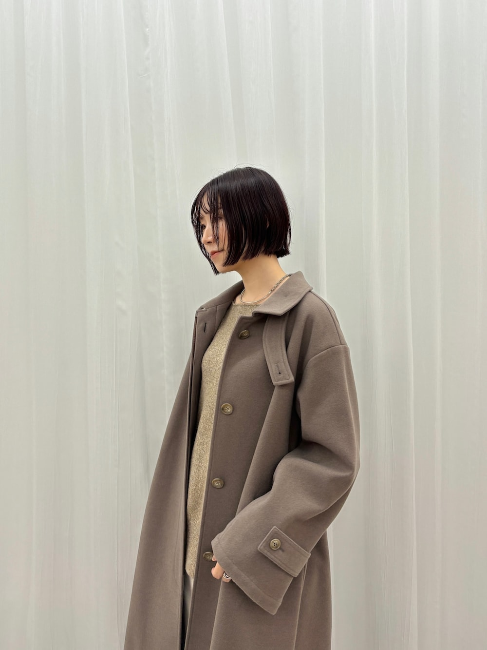 ホワイト系のスカート、ブラウン系のニット/セーター、ブラウン系のステンカラーコートを着用したレディースの秋コーディネートの5枚目の写真