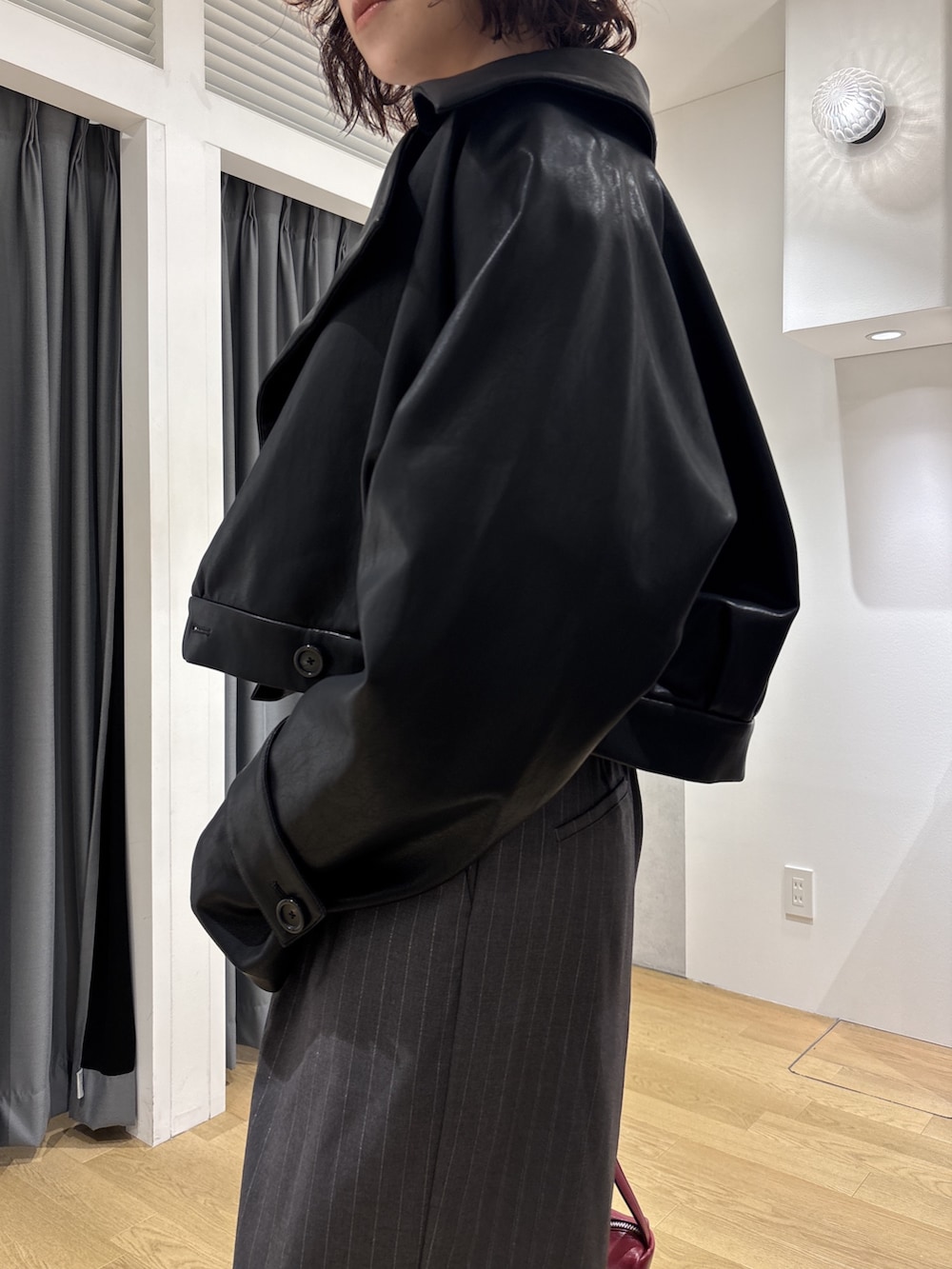 グレー系のその他パンツ、ホワイト系のニット/セーター、レッド系のハンドバッグを着用したレディースの秋コーディネートの6枚目の写真