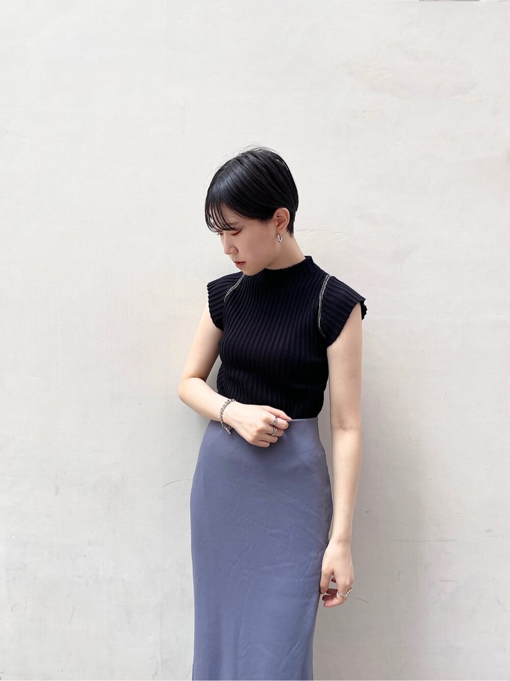 ホワイト系のサンダル、ブルー系のスカート、ブラック系のニット/セーターを着用したレディースの夏コーディネートの6枚目の写真