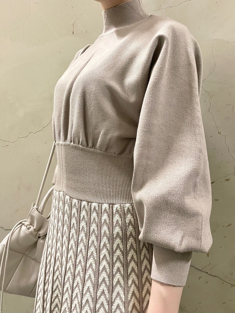 ホワイト系のカーディガン/ボレロ、ベージュ系のブーツ、ホワイト系のハンドバッグを着用したレディースの冬コーディネートの9枚目の写真