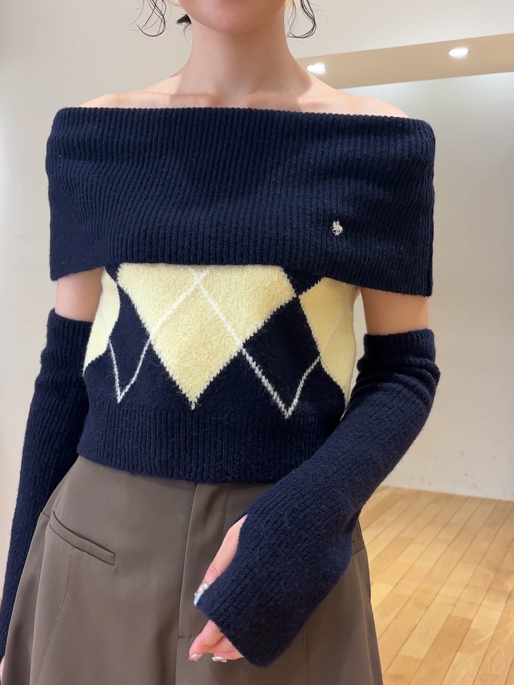 ブラウン系のその他パンツ、ブルー系のニット/セーター、ブラック系のハンドバッグを着用したレディースの夏コーディネートの6枚目の写真