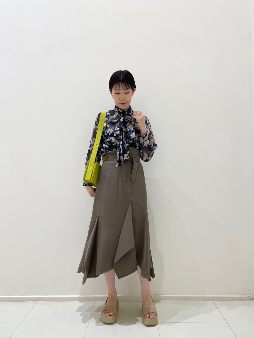 ブラウン系のスカート、ブルー系のシャツ/ブラウス、グリーン系のショルダーバッグを着用したレディースの春コーディネートの3枚目の写真