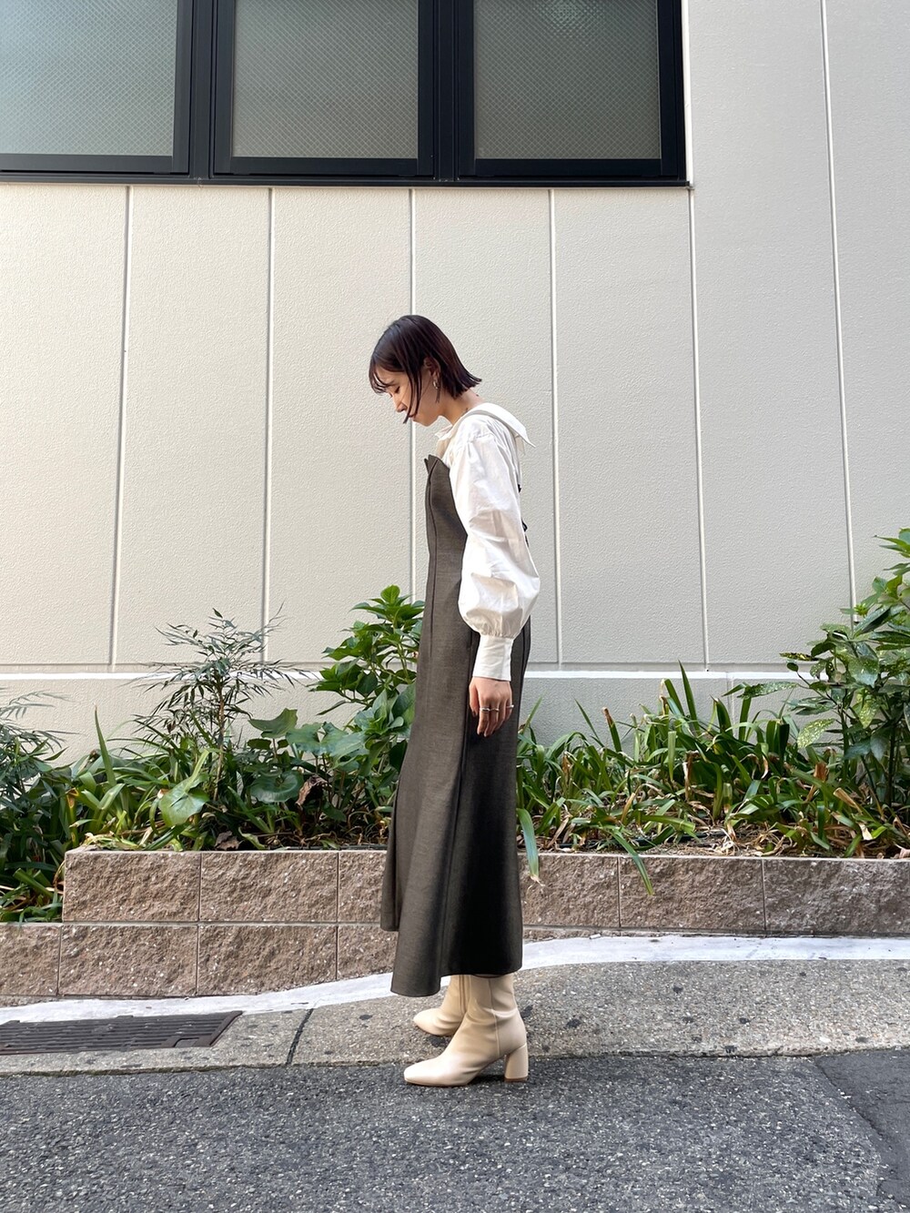 ブラウン系のワンピース、ブルー系のショルダーバッグ、ホワイト系のブーツを着用したレディースの秋コーディネートの4枚目の写真