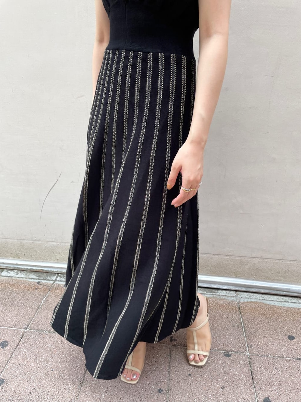 レッド系のサンダル、ブラック系のワンピースを着用したレディースの夏コーディネートの6枚目の写真