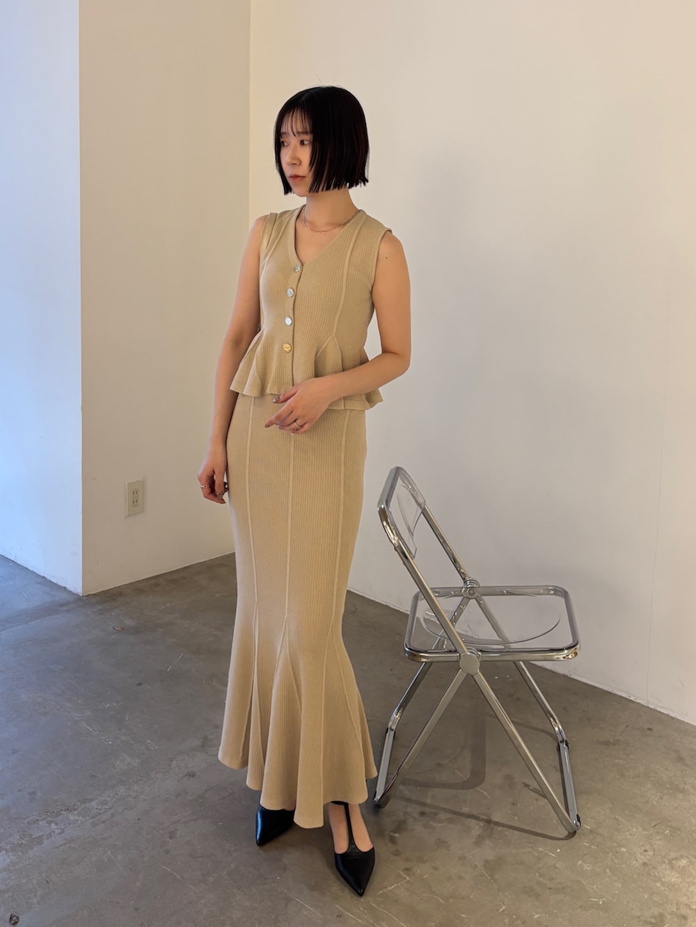 ベージュ系のニット/セーター、ベージュ系のスカート、ブラック系のパンプスを着用したレディースの春コーディネートの2枚目の写真