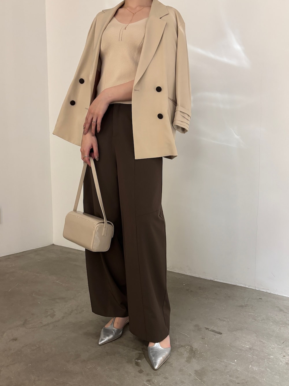 シルバー系のパンプス、ブラウン系のその他パンツ、ベージュ系のテーラードジャケットを着用したレディースの春コーディネートの3枚目の写真