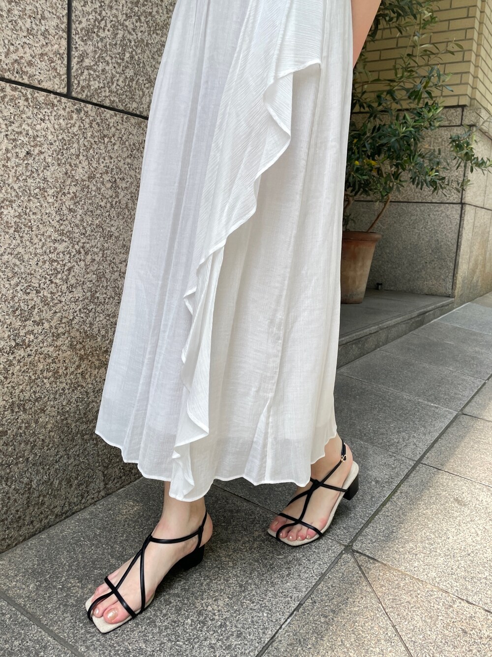 ブラウン系のショルダーバッグ、ホワイト系のワンピース、シルバー系のチョーカーを着用したレディースの夏コーディネートの7枚目の写真