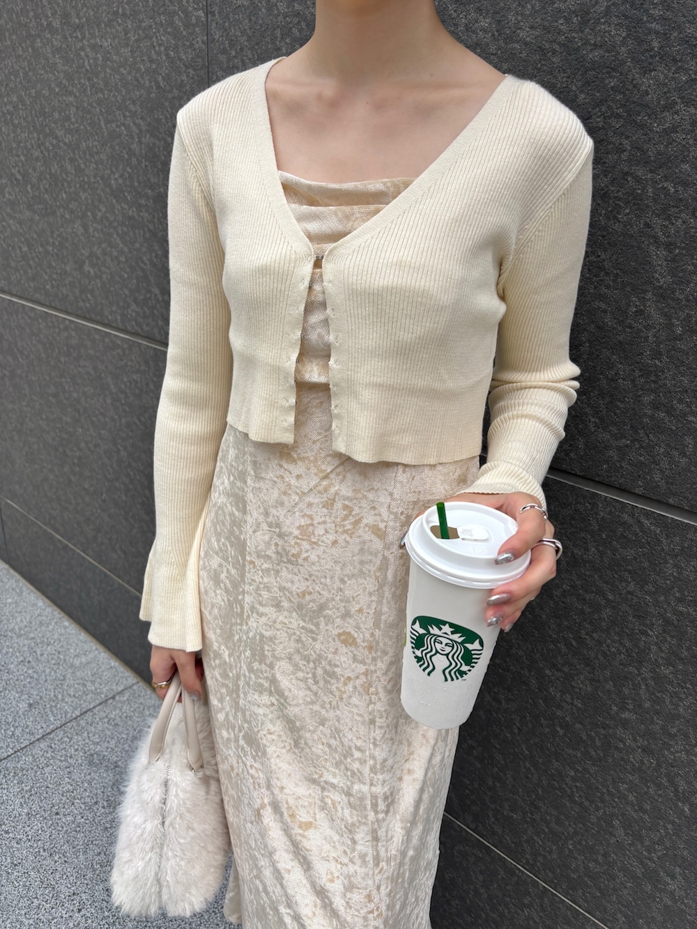 ベージュ系のワンピース、ホワイト系のボストンバッグ、ブラウン系のパンプスを着用したレディースの秋コーディネートの7枚目の写真