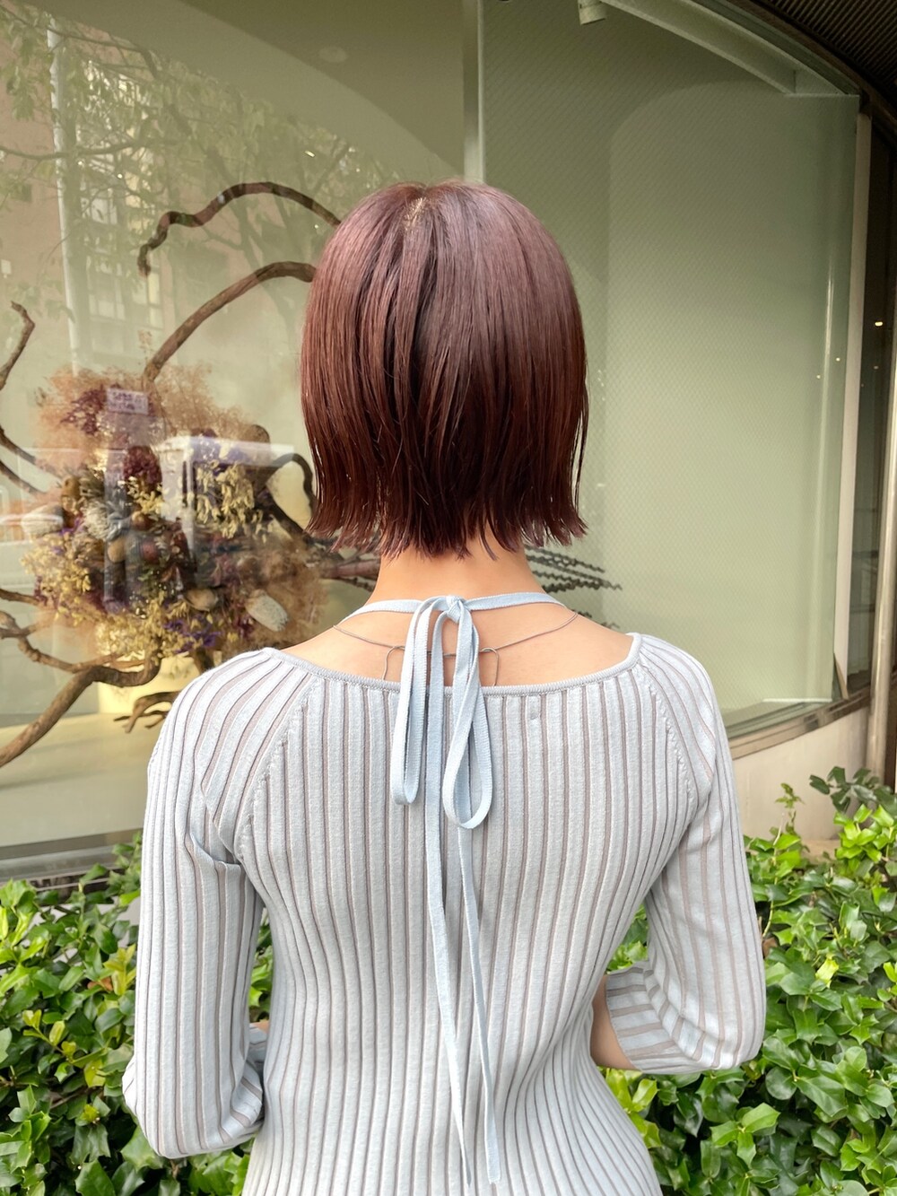 ブラック系のスカート、ブルー系のニット/セーター、ホワイト系のパンプスを着用したレディースの春コーディネートの8枚目の写真