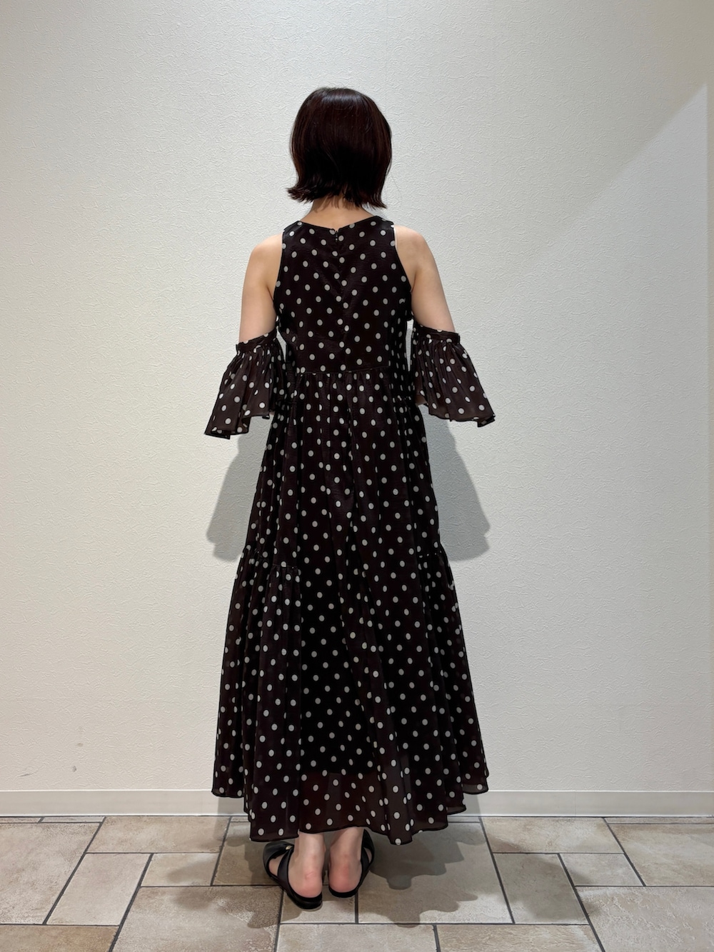 ブラウン系のワンピース、ブラウン系のハンドバッグ、ブラウン系のサンダルを着用したレディースの夏コーディネートの4枚目の写真