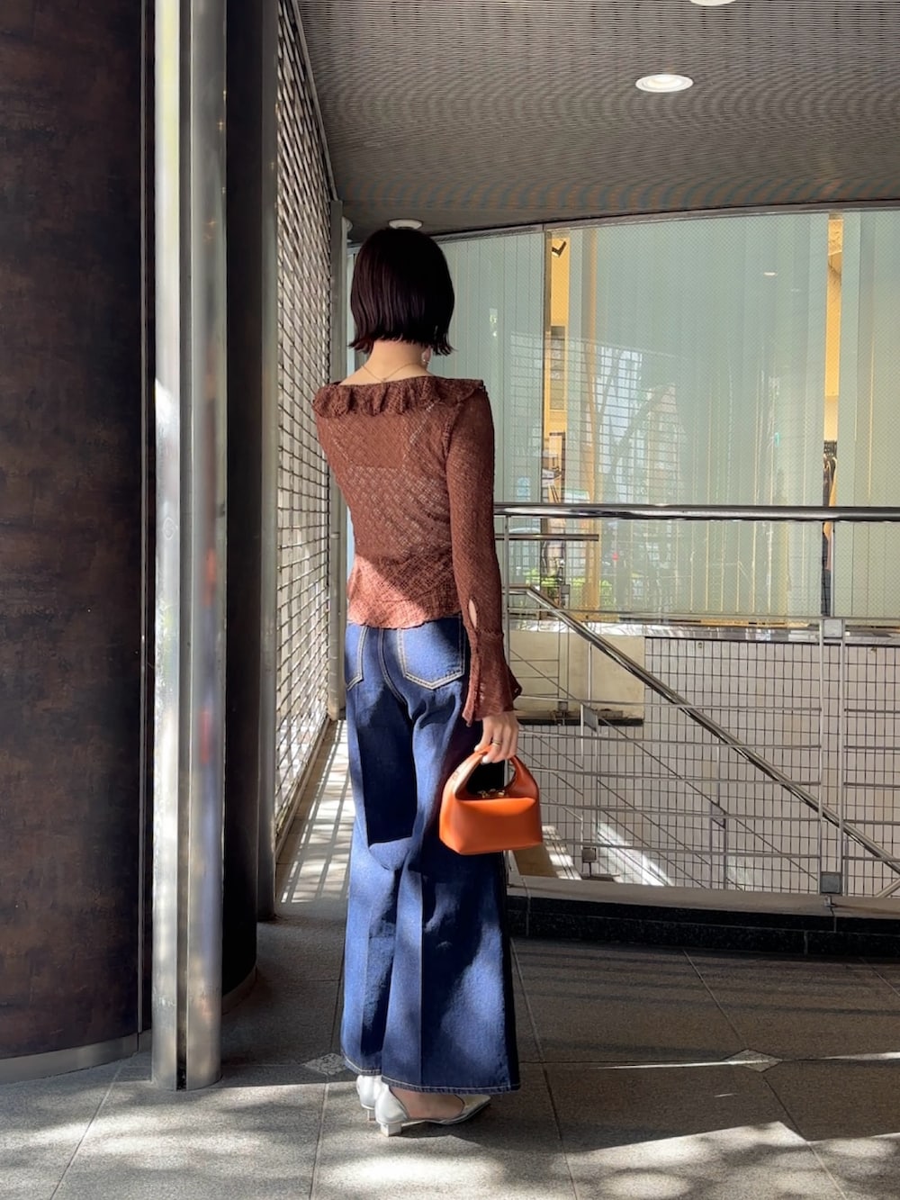 ブラウン系のシャツ/ブラウス、シルバー系のパンプス、ブラウン系のハンドバッグを着用したレディースの冬コーディネートの3枚目の写真