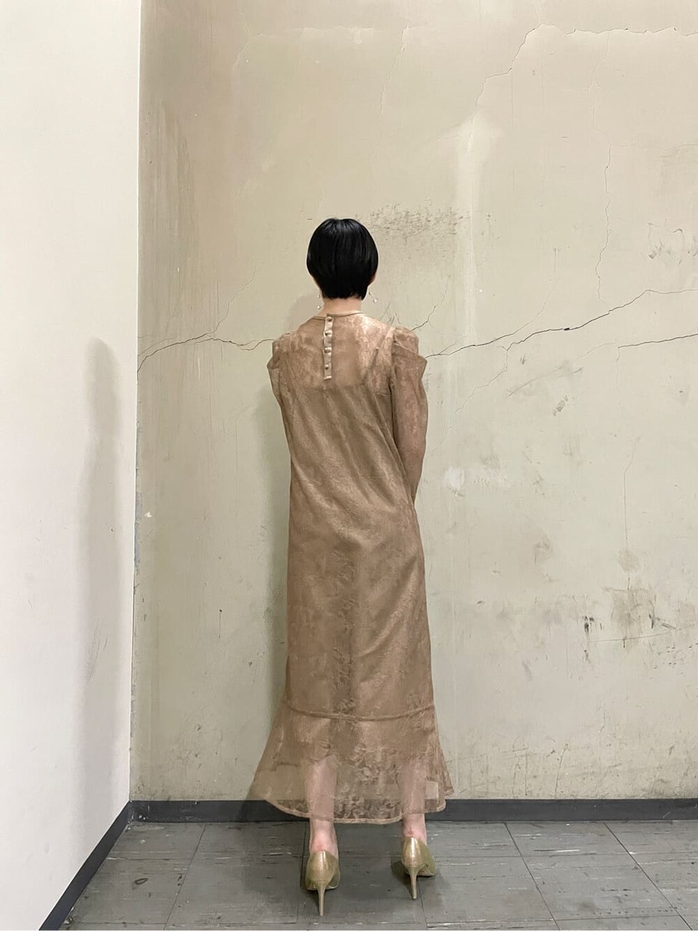 ゴールド系のパンプス、ベージュ系のドレス、ゴールド系のハンドバッグを着用したレディースの秋コーディネートの4枚目の写真