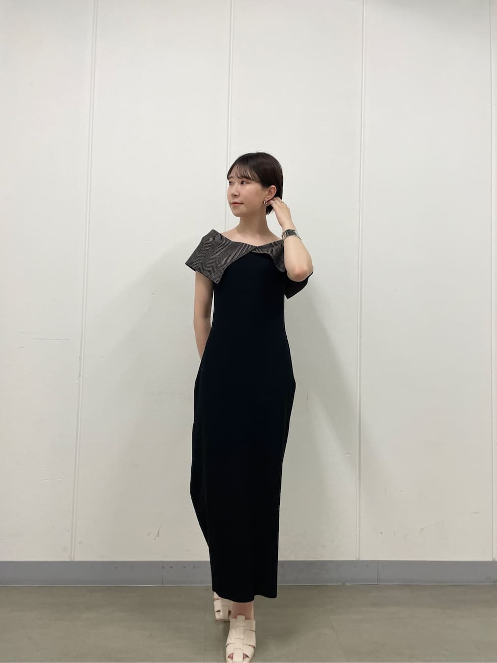 ホワイト系のサンダル、ブラック系のワンピース、シルバー系のバングル/リストバンドを着用したレディースの夏コーディネートの2枚目の写真