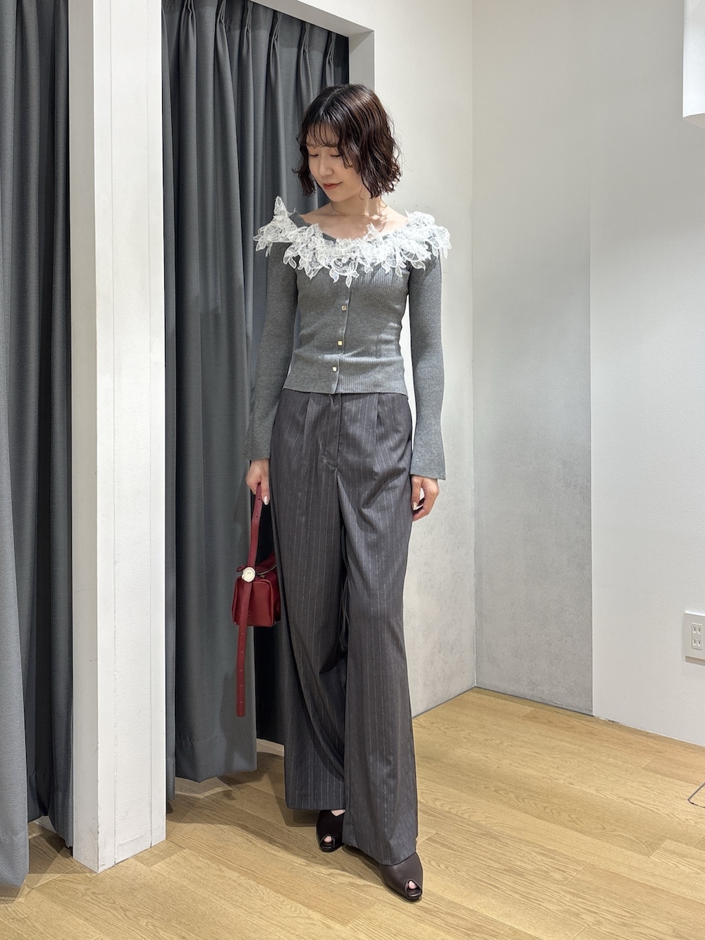 グレー系のその他パンツ、レッド系のハンドバッグ、ブラウン系のパンプスを着用したレディースの秋コーディネートの2枚目の写真