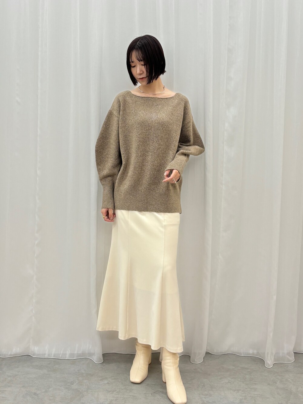 ホワイト系のスカート、ブラウン系のニット/セーター、ブラウン系のステンカラーコートを着用したレディースの秋コーディネートの7枚目の写真