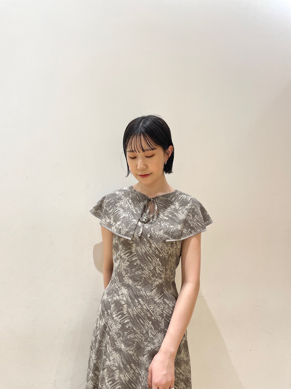 グレー系のワンピース、ホワイト系のハンドバッグ、ベージュ系のサンダルを着用したレディースの夏コーディネートの8枚目の写真